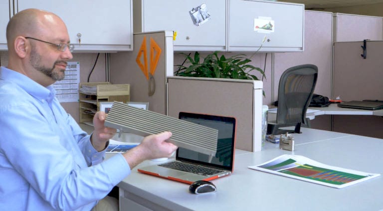 Daryn Bertelson with a radiator grille manufactured by Johnson Screens